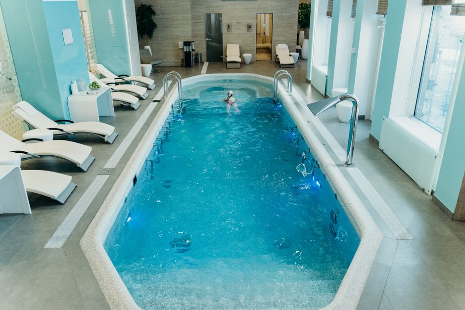 Bright indoor spa pool with lounge chairs and calm atmosphere