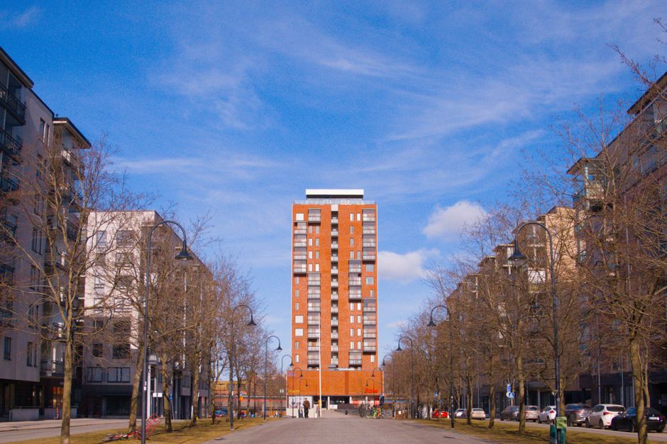 Modern urban scene featuring a tall red brick building in Tampere, Finland